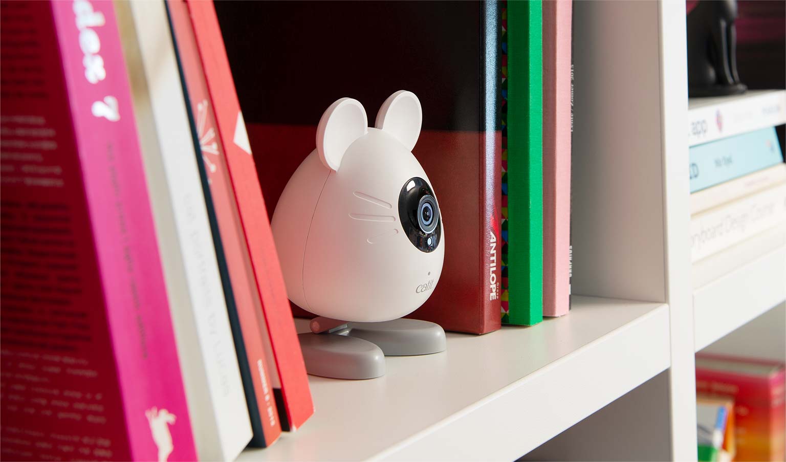Kamera PIXI Smart w kształcie myszki na półce z książkami