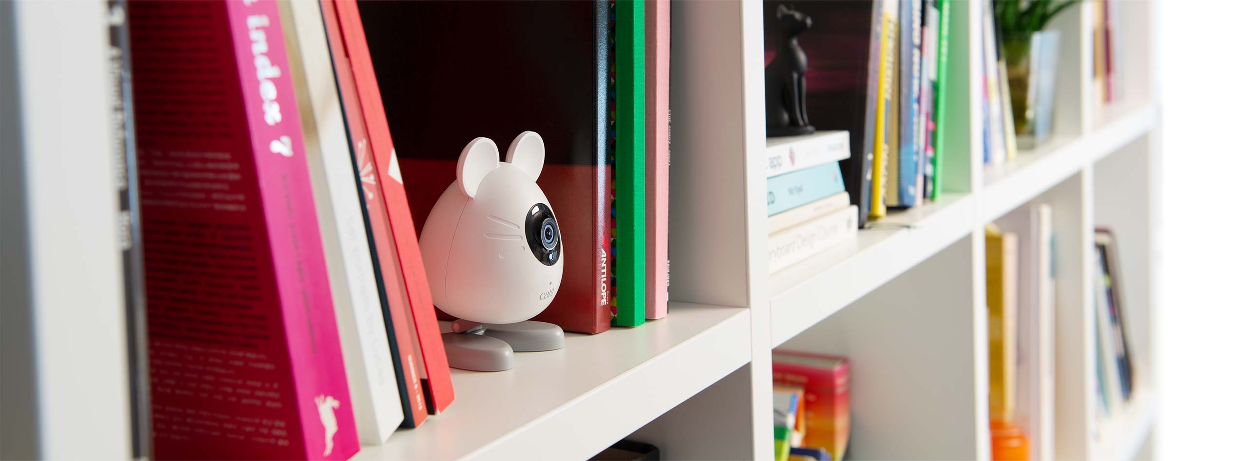 Kamera PIXI Smart w kształcie myszki na półce z książkami
