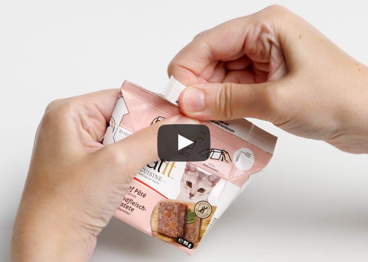 Hands opening a Catit Cuisine wet cat food pouch