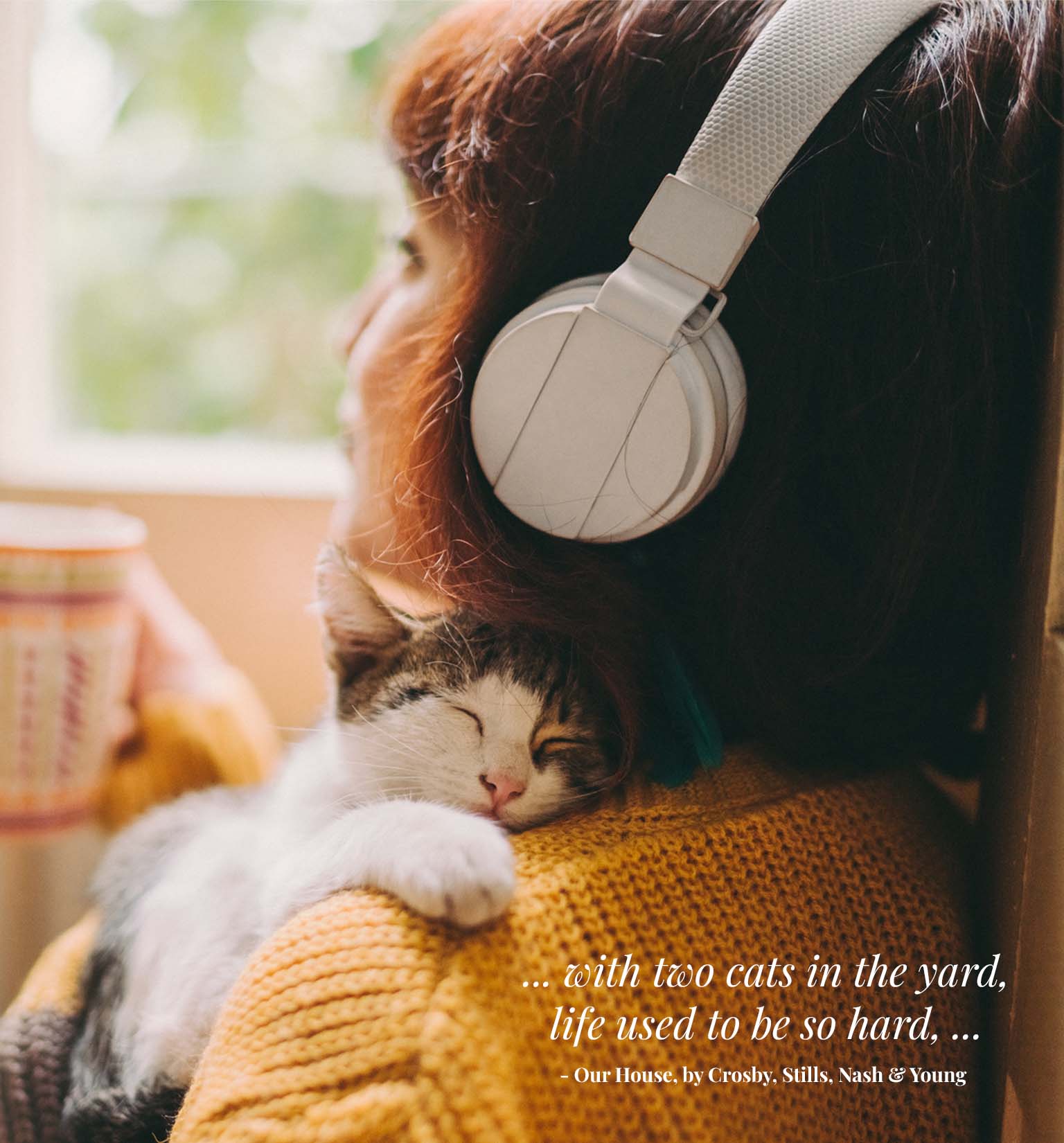 A person wearing headphones holds a sleeping cat on their shoulder, accompanied by a quote from the song Our House