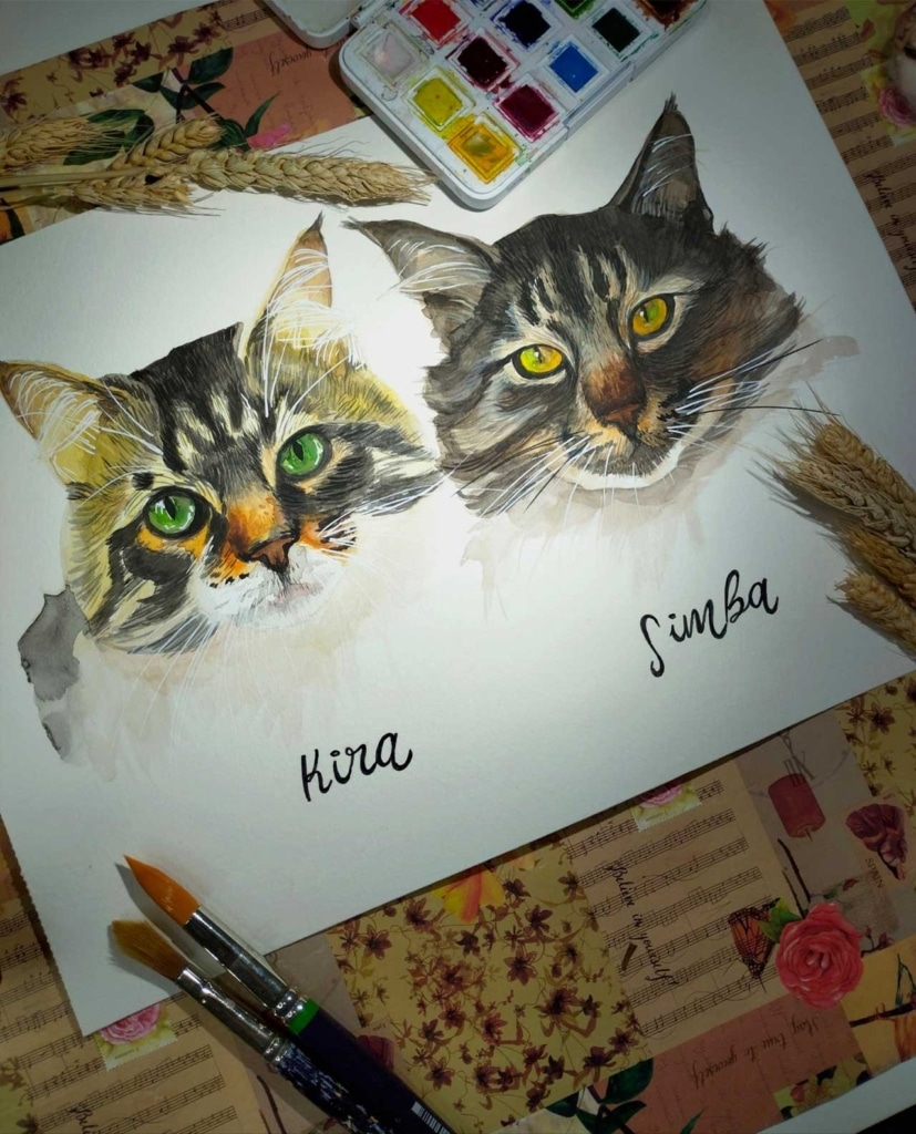 A watercolor painting of two cats, Kira with green eyes and Simba with yellow eyes, with paint supplies and wheat stalks