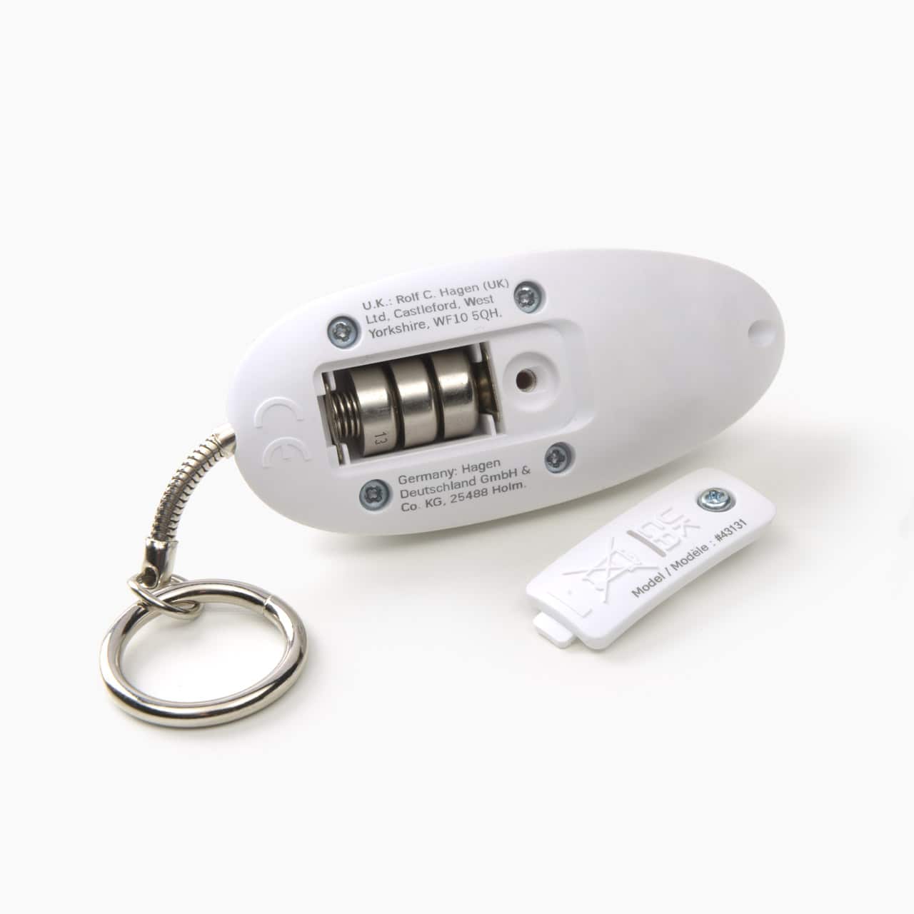 Open battery compartment of a white Catit laser toy with three button cell batteries visible and the detached cover nearby