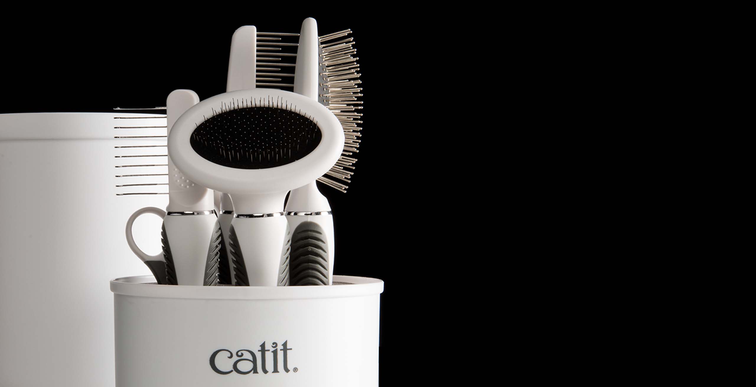 Catit grooming kit with various brushes and combs stored in a white container