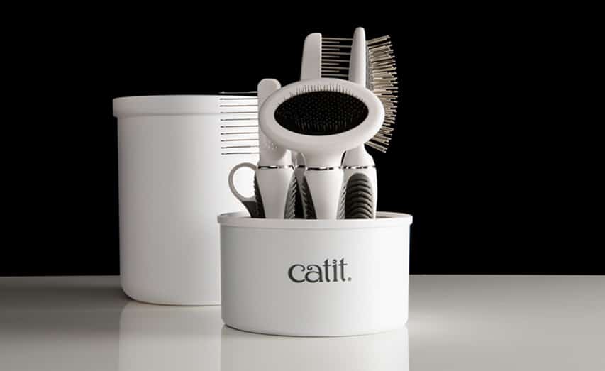 Catit grooming kit with various brushes stored in a white container