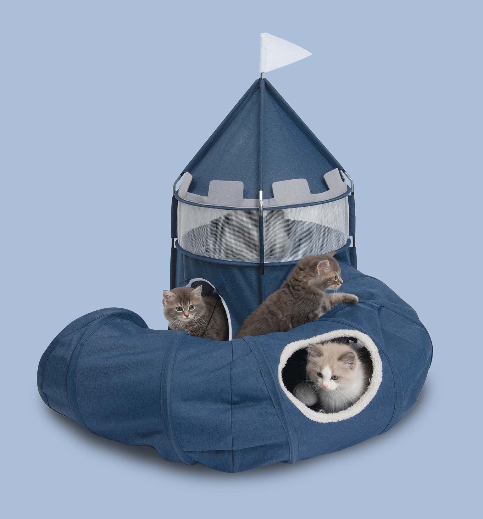 Three kittens playing in and around a blue fabric cat castle with an attached tunnel and a white flag on top