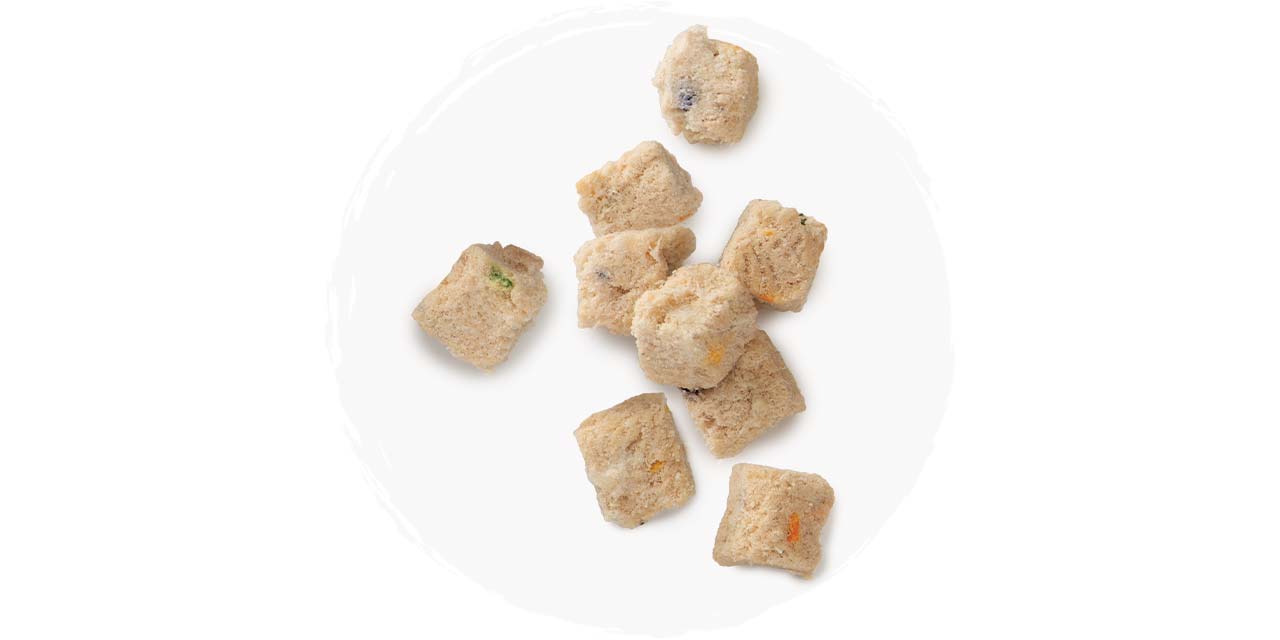Freeze-dried raw crocodile meat cubes for cats on a white background