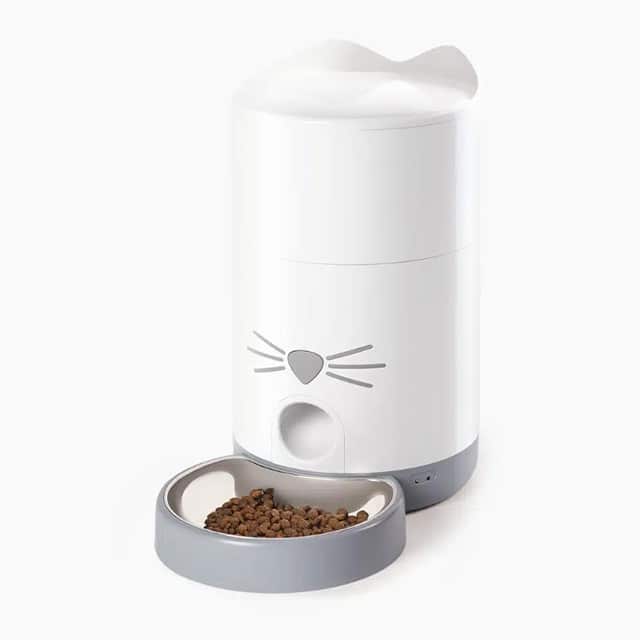 Catit PIXI Smart Feeder with a white cat-shaped container and a grey bowl filled with dry cat food