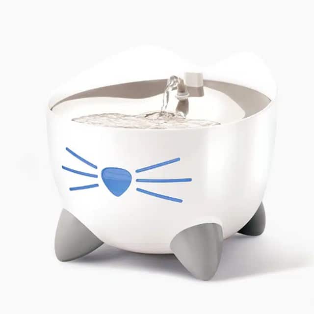 White cat-shaped PIXI smart water fountain with a blue nose and whiskers design and grey feet