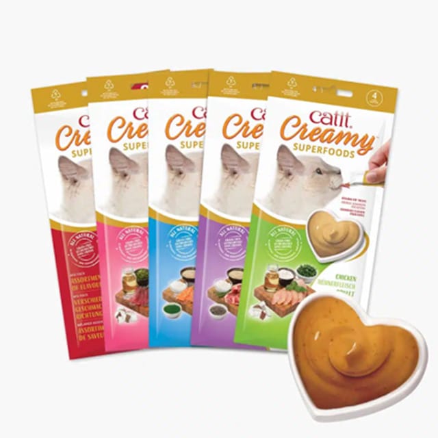 Catit Creamy Superfoods cat treat tubes in various flavors with a heart-shaped dish of the creamy treat