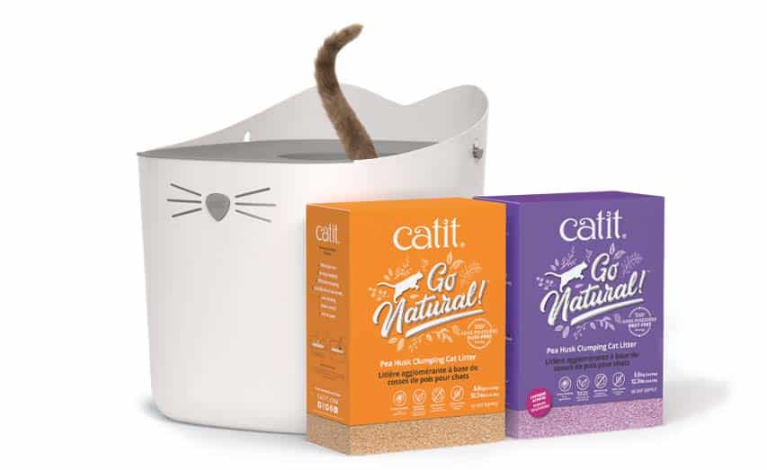 A white cat-shaped litter box with a cat tail visible inside, next to two packages of Catit Go Natural pea husk cat litter