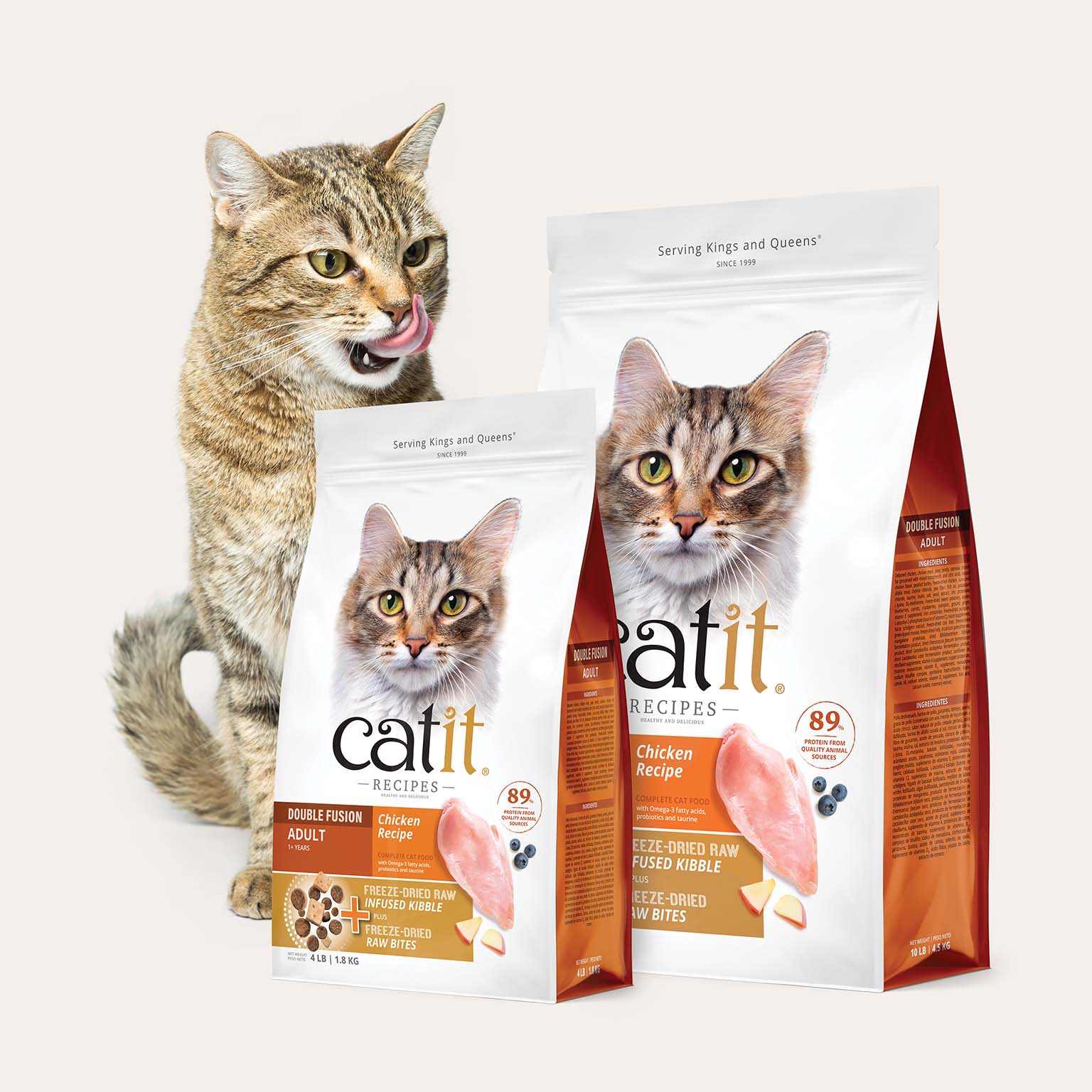 A tabby cat licking its lips next to two bags of Catit Recipes Double Fusion adult cat food