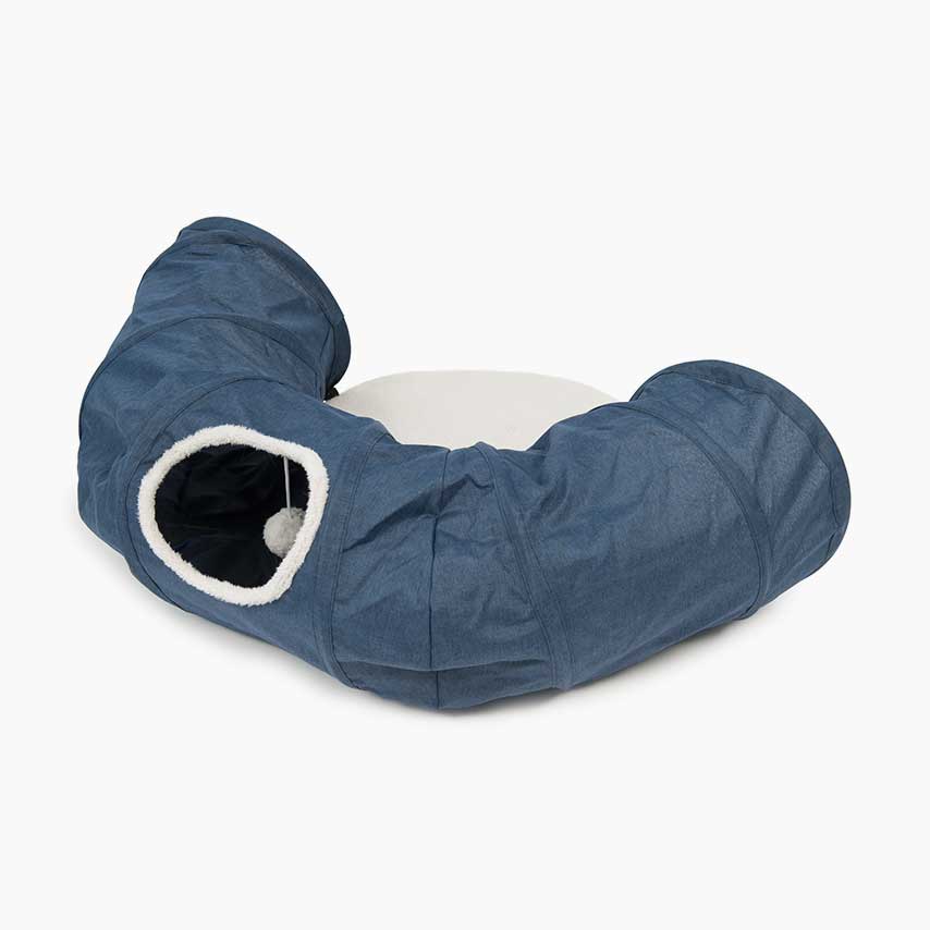 Blue curved cat tunnel with a plush white interior and a hanging toy ball