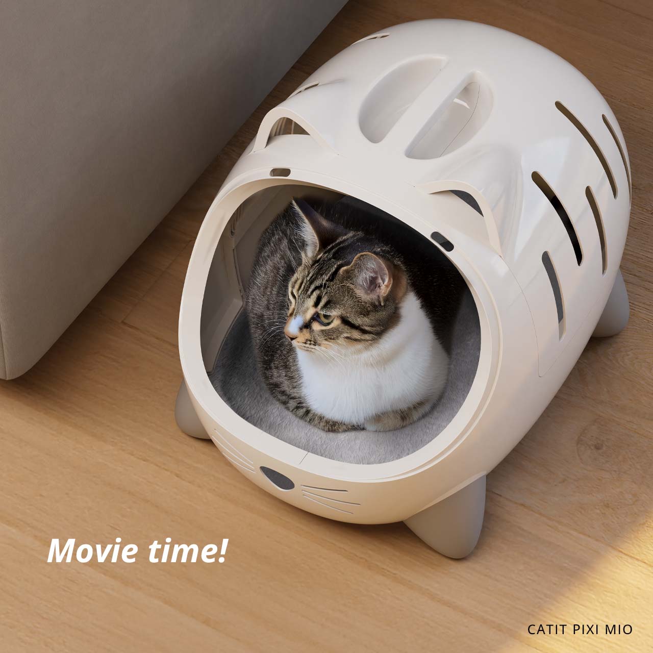 A tabby cat resting inside a beige, cat-shaped PIXI MIO pet bed on a wooden floor