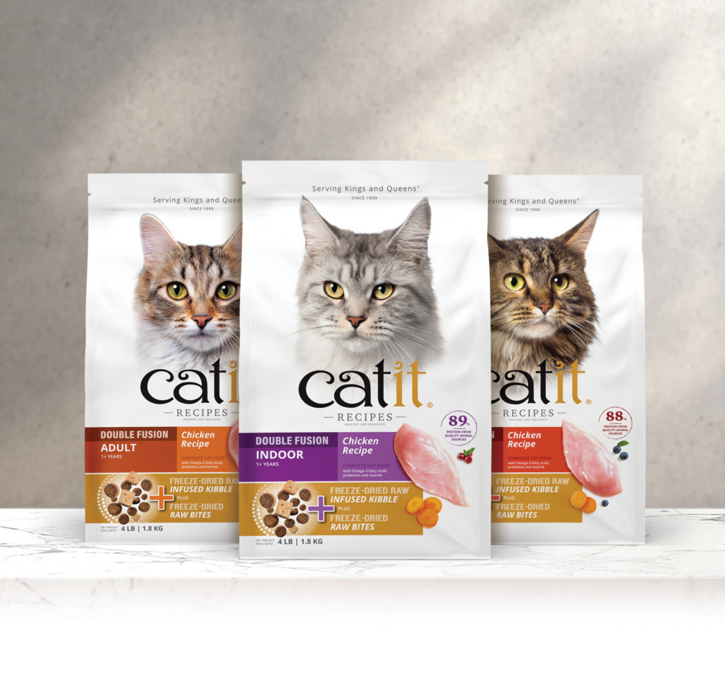 Three bags of Catit Recipes cat food featuring photos of cats and product details on a marble surface