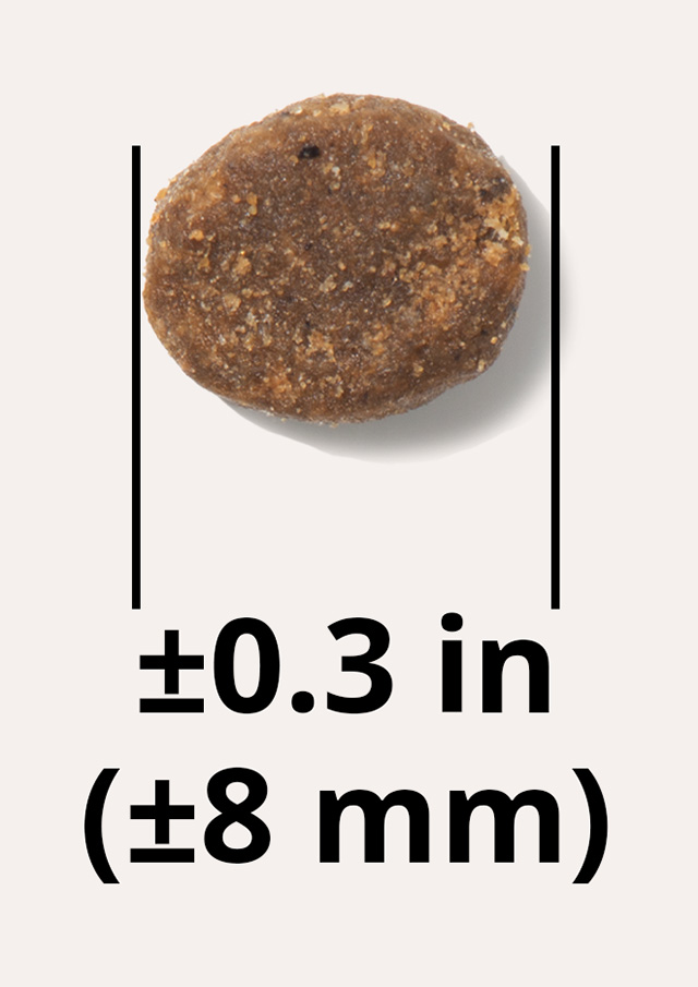 A single brown, round cat food pellet with vertical lines indicating a diameter of approximately 0.3 inches or 8 millimeters