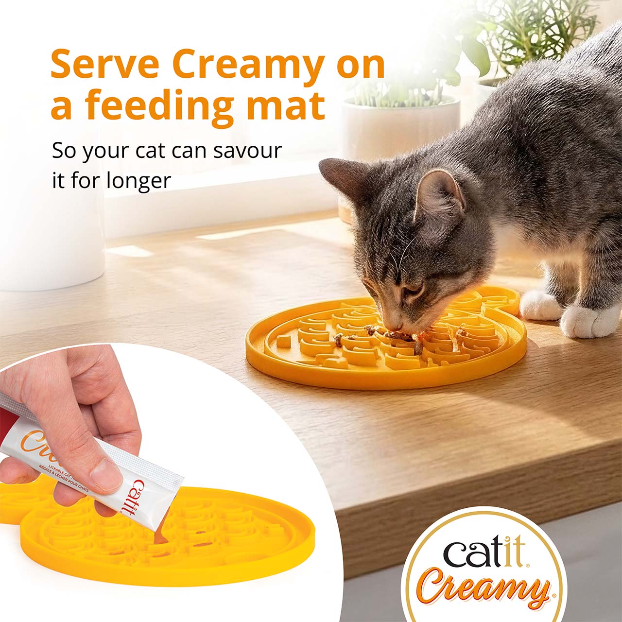 A cat eating Catit Creamy treat from a yellow textured feeding mat, with an inset showing the treat being squeezed onto it