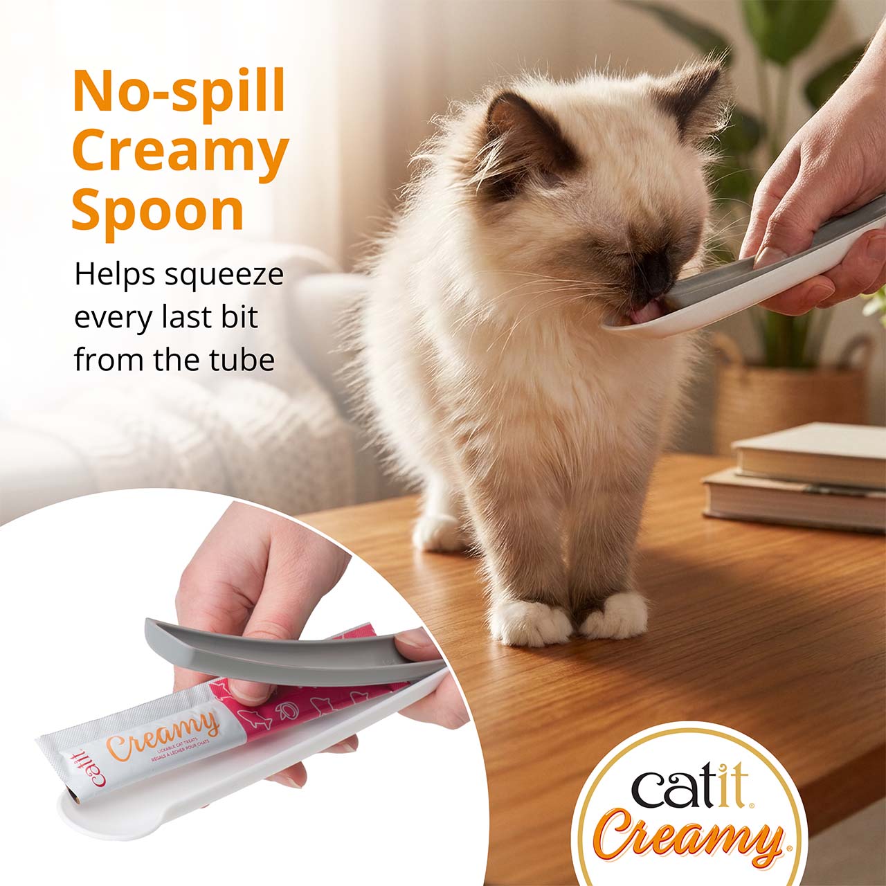 A person uses a Catit Creamy spoon to squeeze a treat tube for a cat to lick