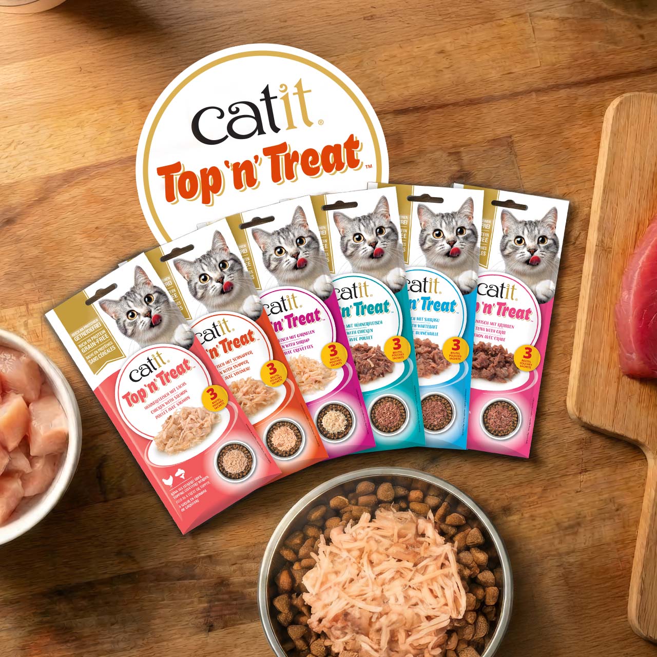 Confezioni di Catit Top ’n’ Treat appoggiate su un piano di lavoro in legno