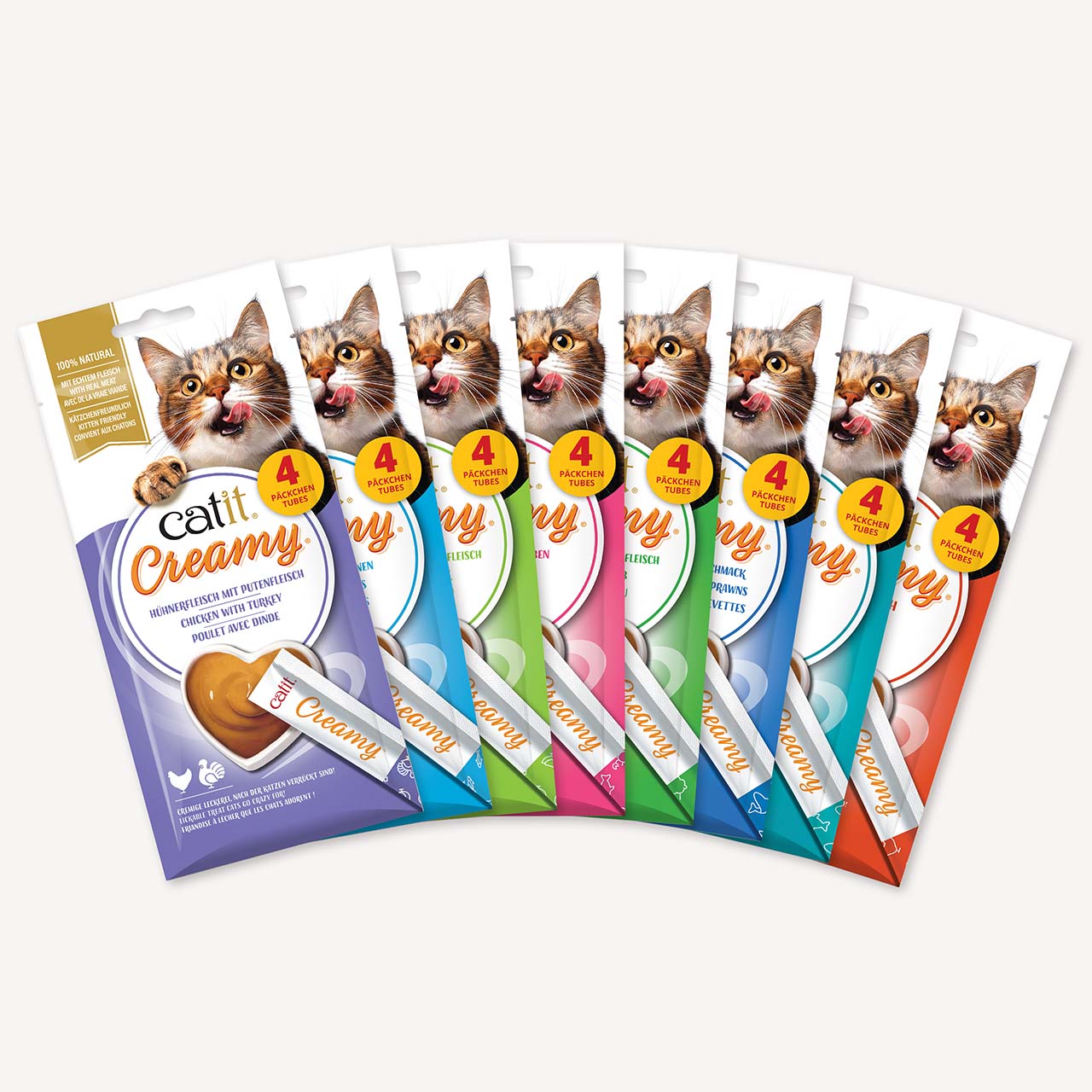 A fan of eight Catit Creamy cat treat packages in various flavors, each featuring a cat and containing four tubes