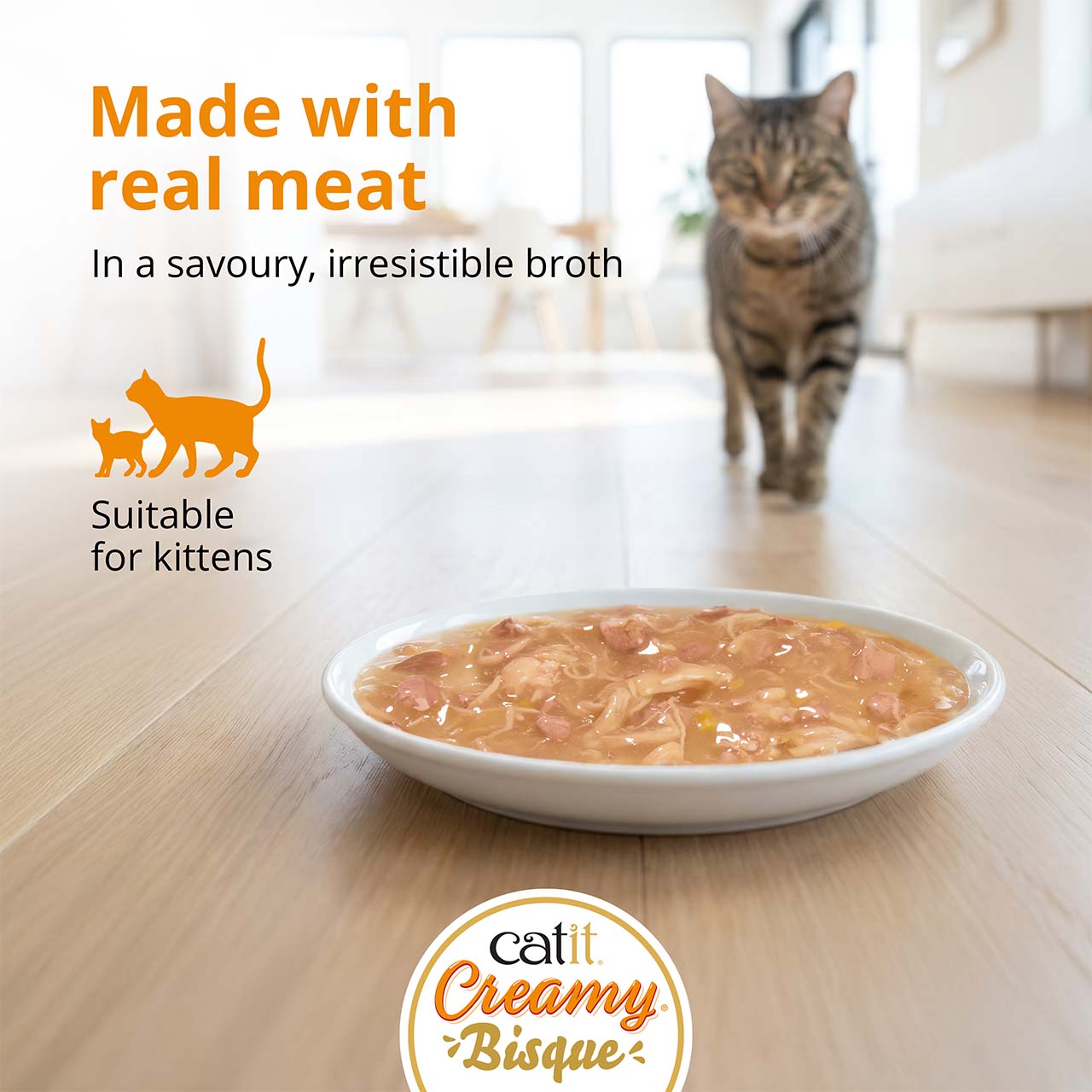 Catit Creamy Bisque cat food in a bowl with a cat walking toward it, highlighting that it is made with real meat for kittens