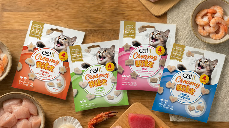 Four packages of Catit Creamy Bitz cat treats in Chicken & Scallops, Chicken & Duck, Tuna, and Salmon & Prawns flavors
