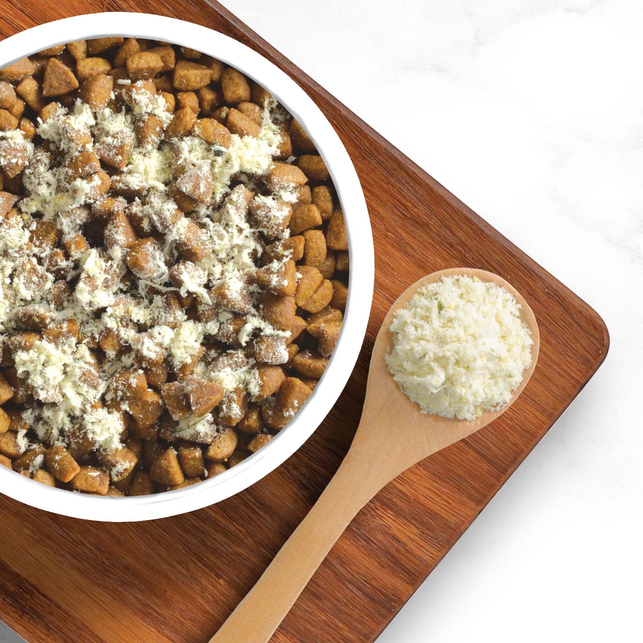 A white bowl filled with dry cat food topped with a light-colored powder, next to a wooden spoon holding the same powder