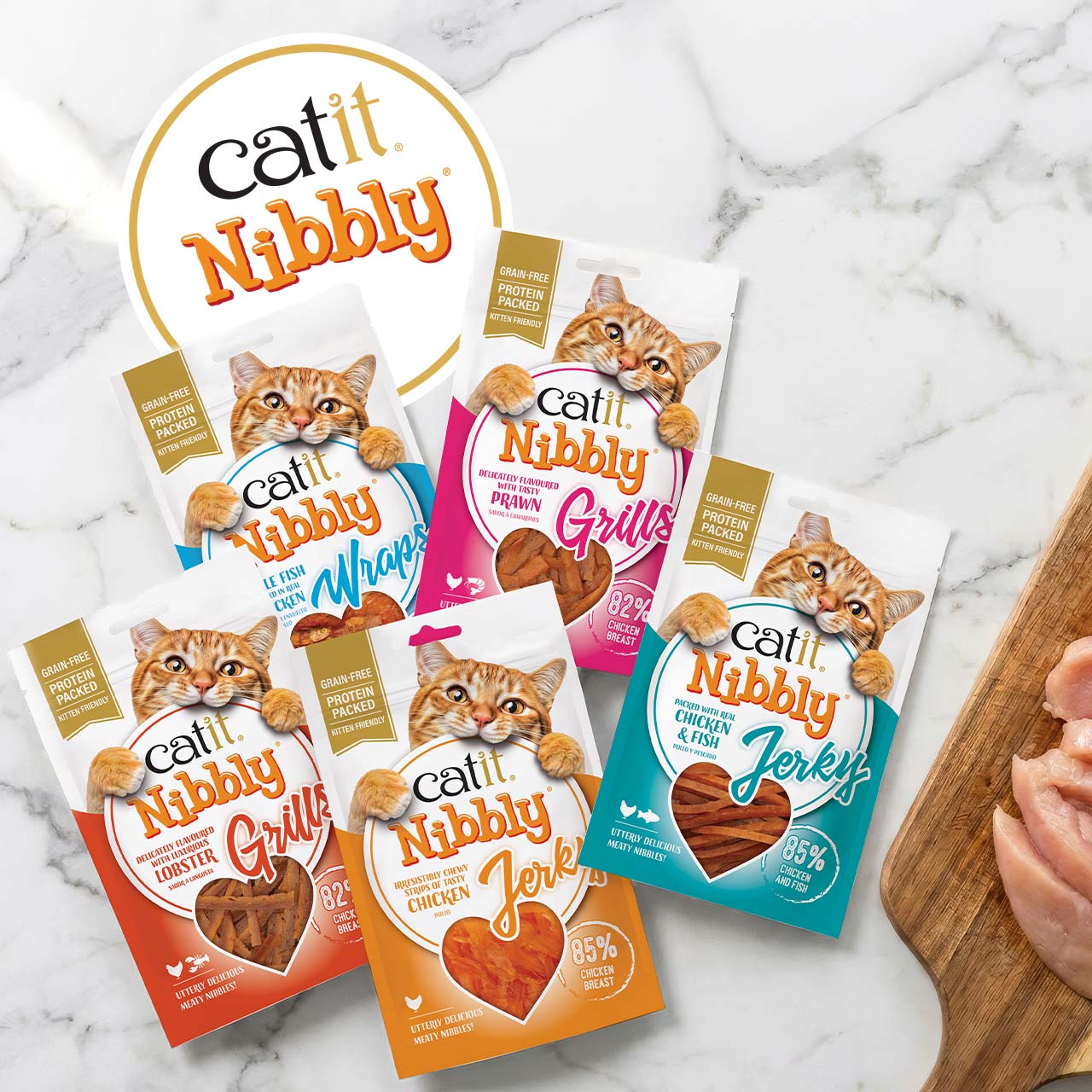 Five packages of Catit Nibbly cat treats in various flavors, including Grills, Jerky, and Wraps, arranged on a marble surface