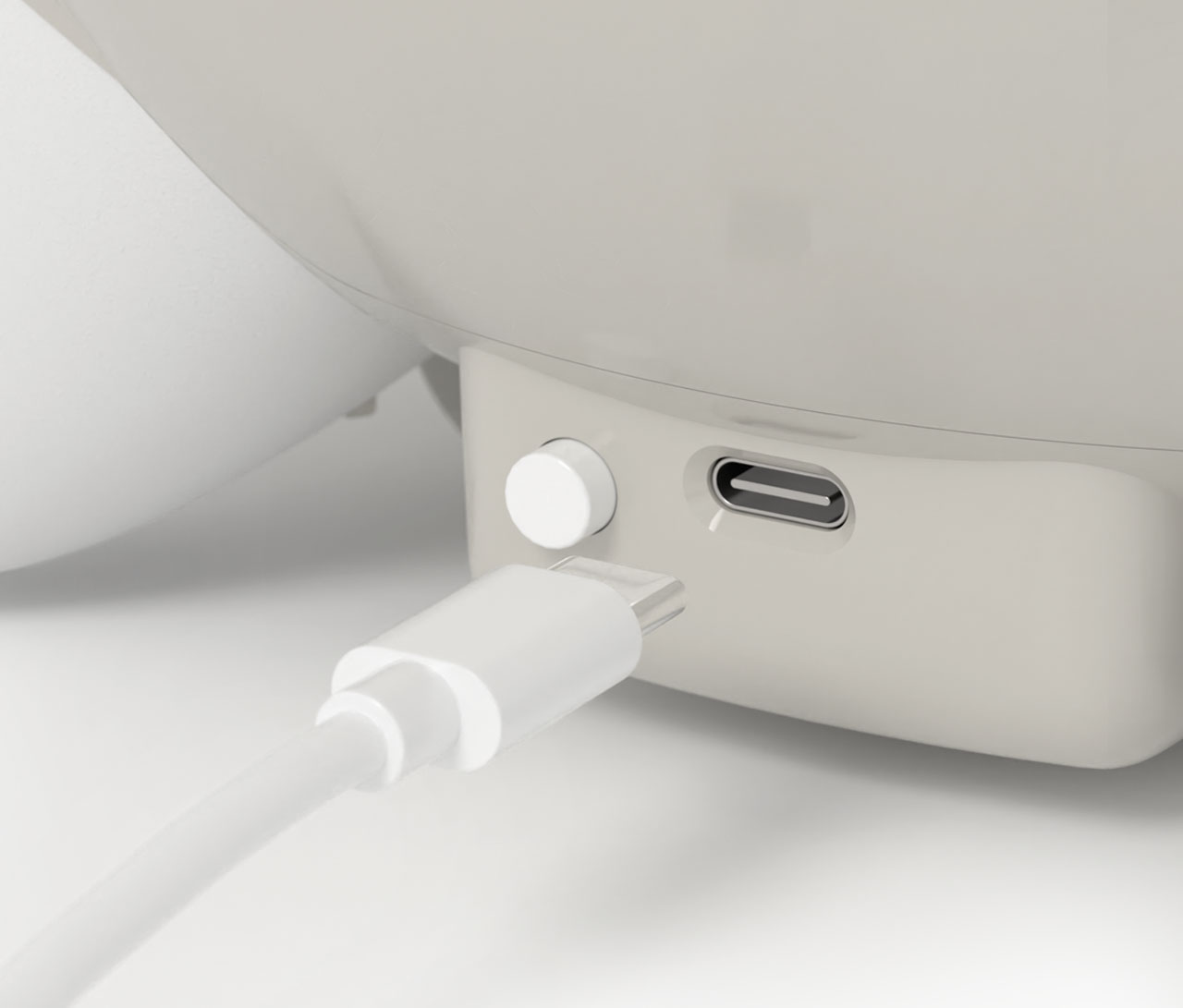 Close-up of a Catit PIXI fountain base showing a white power button and a USB-C charging port with a cable nearby