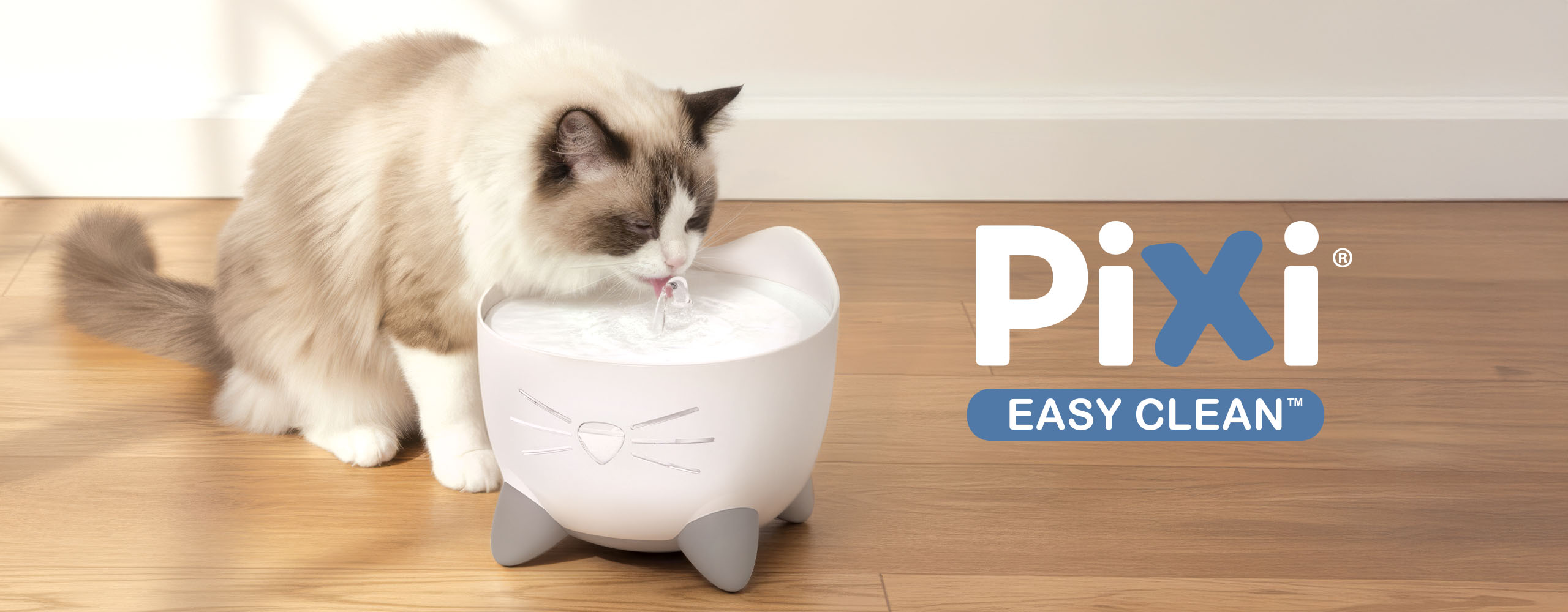 A cat drinking from a white PIXI Easy Clean cat water fountain shaped like a cat face