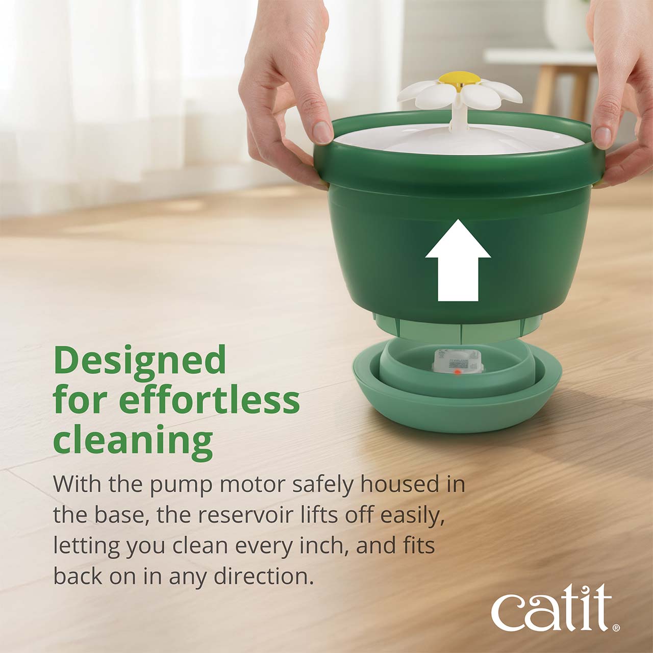 A person lifting the reservoir off the base of a Catit flower water fountain to demonstrate its easy-to-clean design