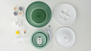 Disassembled parts of a Catit PIXI cat water fountain, including the basin, pump, filter, and lid components