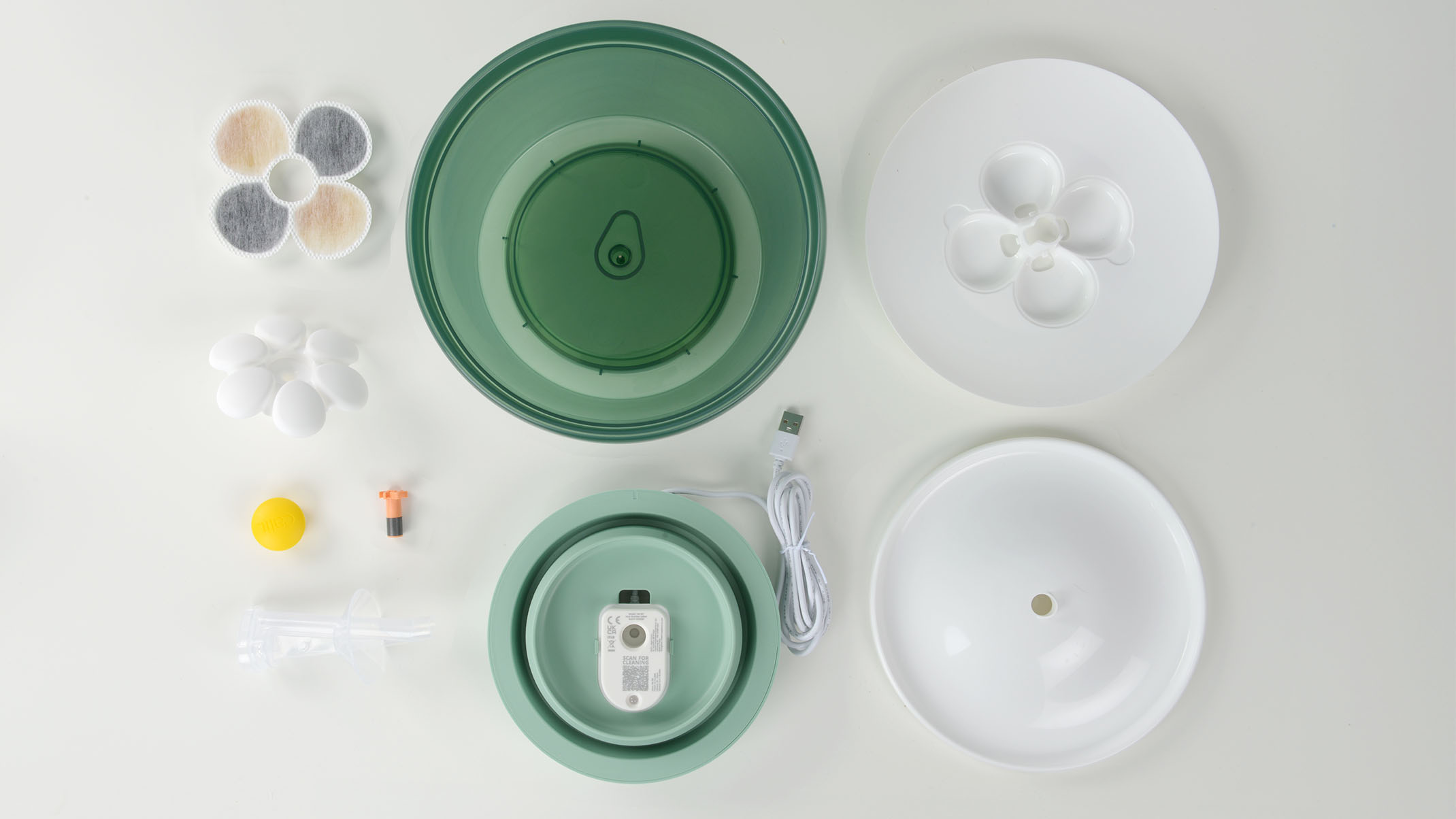 Disassembled parts of a Catit PIXI cat water fountain, including the basin, pump, filter, and lid components
