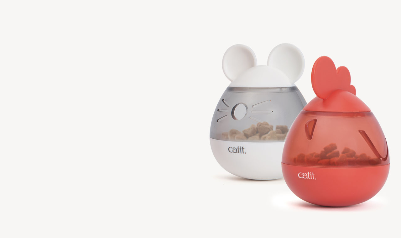 Two Catit PIXI treat dispensers shaped like a mouse and a chicken, filled with dry cat food