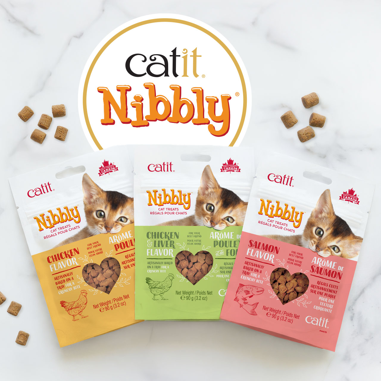 Three bags of Catit Nibbly cat treats in Chicken, Chicken & Liver, and Salmon flavors arranged on a marble surface