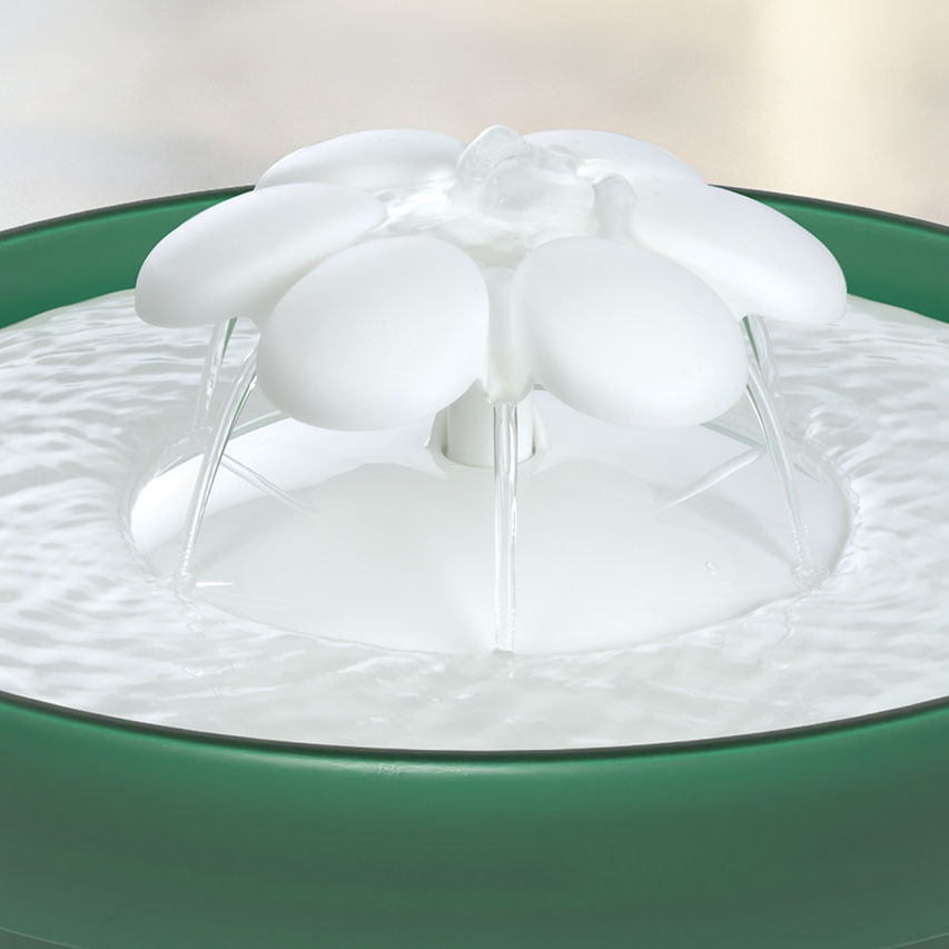 A green cat water fountain with a white flower-shaped top that creates a gentle water flow
