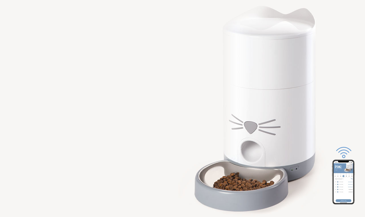 Catit PIXI smart cat feeder with a stainless steel bowl and a smartphone displaying the app interface