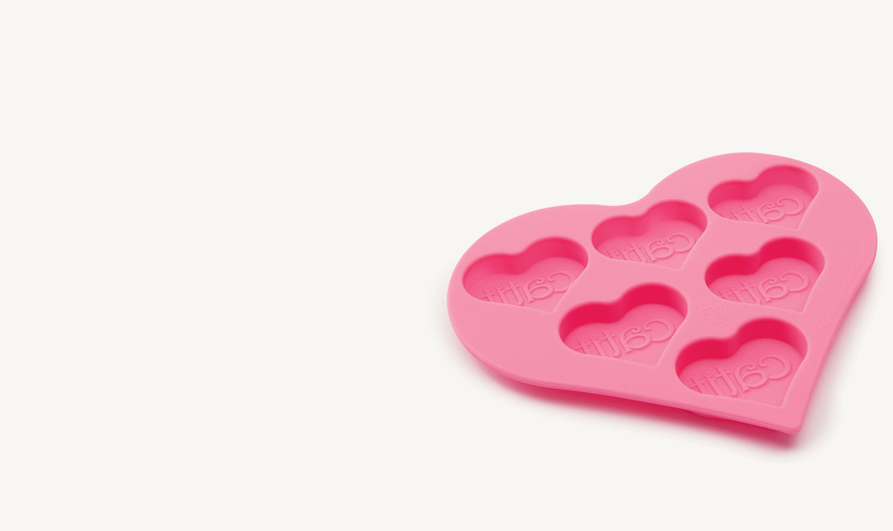 Pink silicone heart-shaped treat mold with six cavities, each embossed with the Catit logo