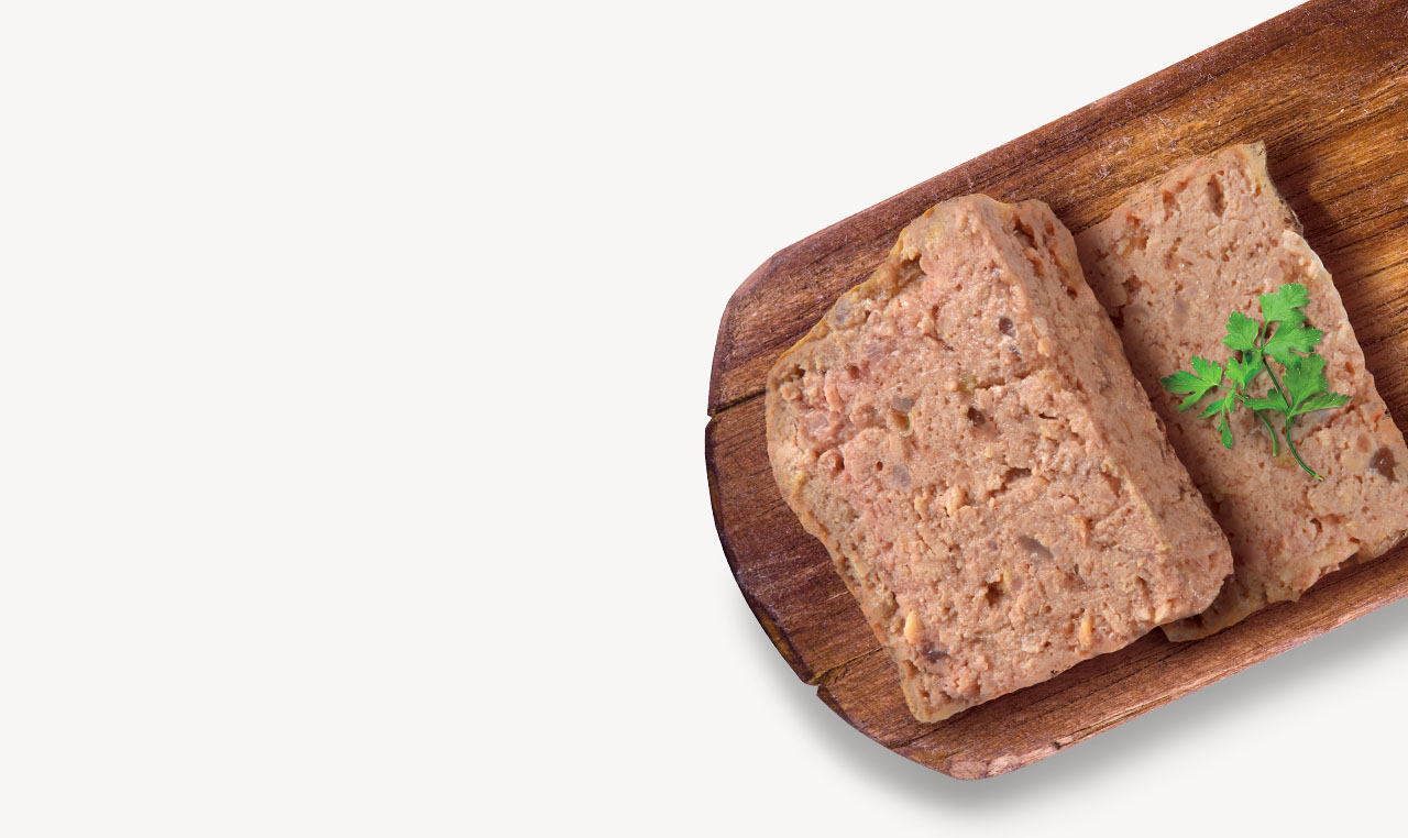 Two slices of meat pâté on a wooden board garnished with a sprig of parsley