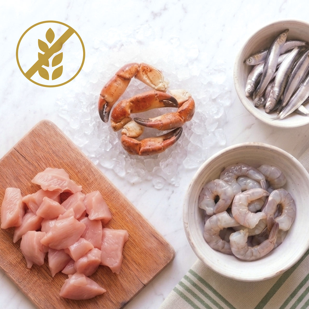 Raw chicken pieces on a cutting board, crab claws on ice, and a bowl of shrimp with a gluten-free icon