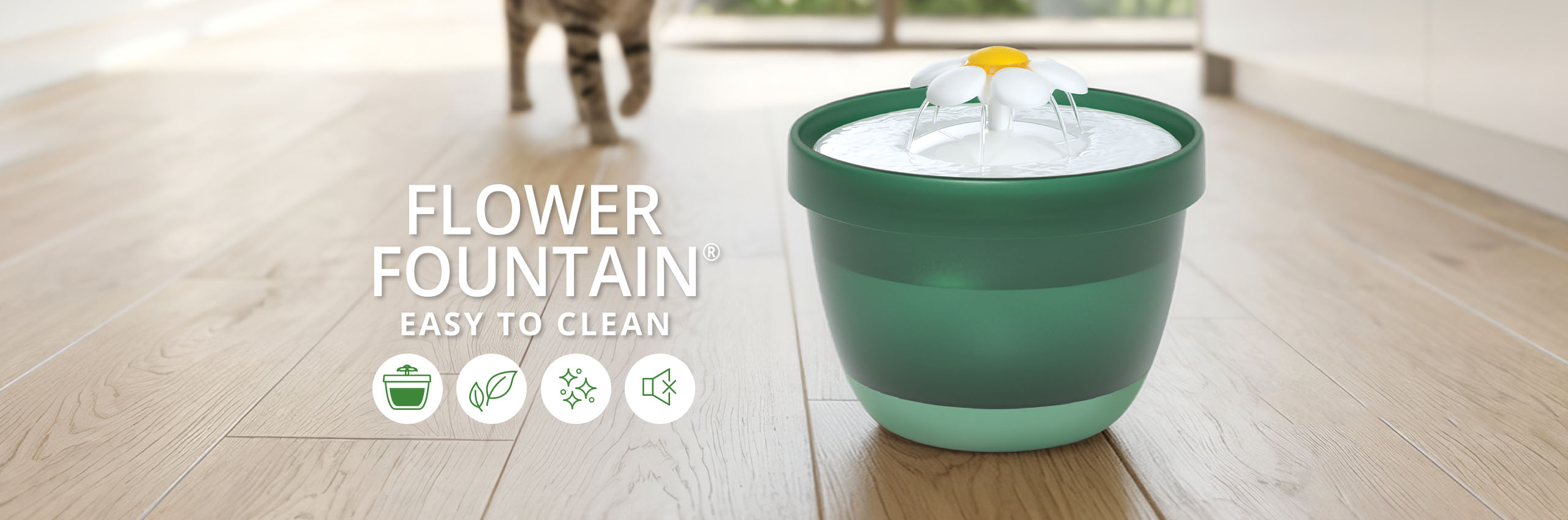 Catit Flower Fountain for cats, featuring a green bowl with a daisy-shaped water spout on a wooden floor