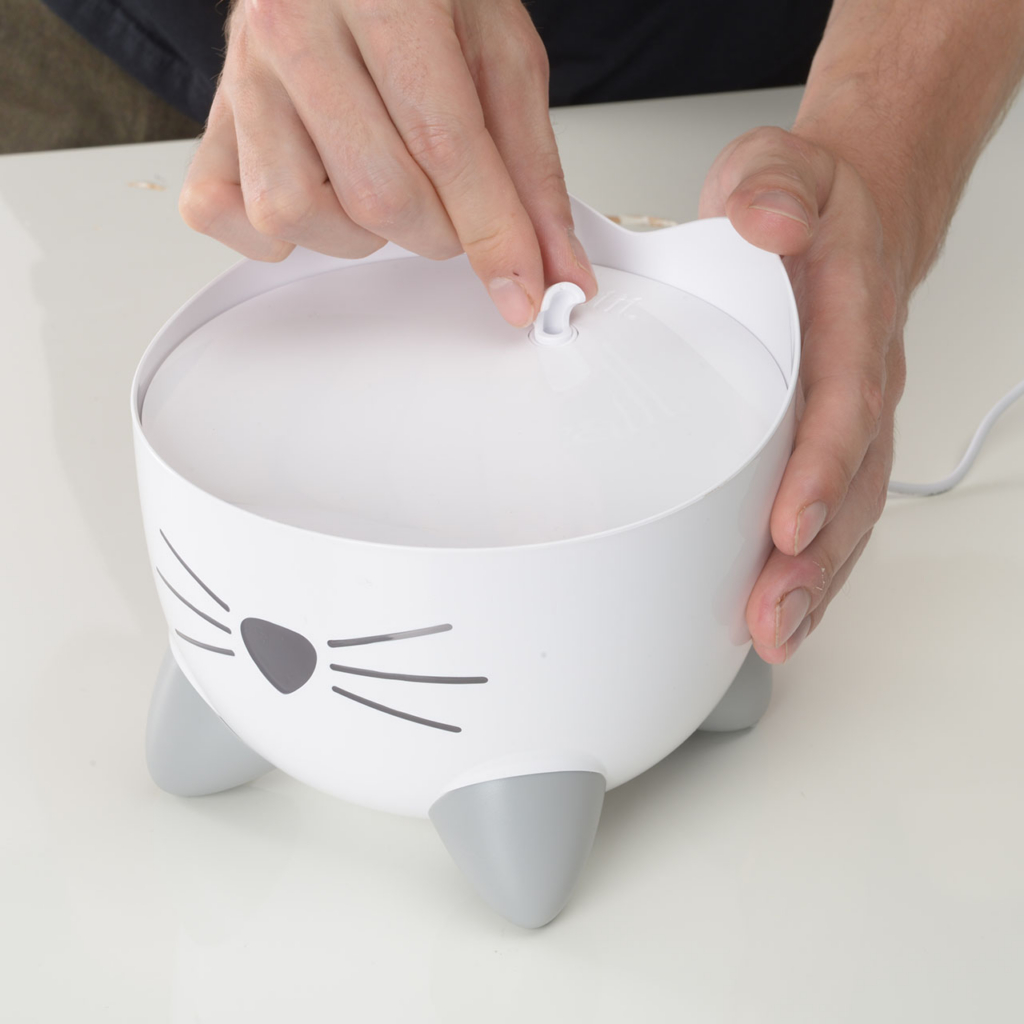 Hands adding spout on the PIXI Mini Fountain