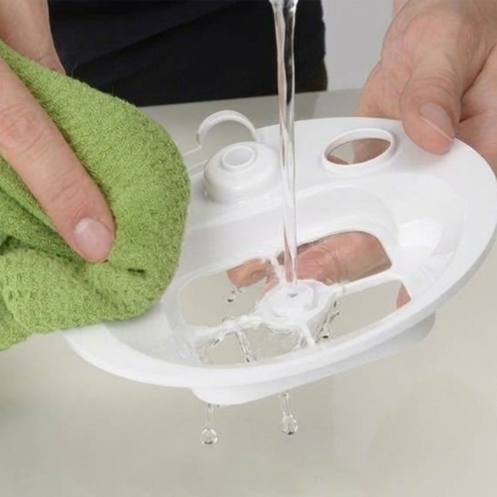Hands cleaning PIXI mini fountain filter tray with cloth