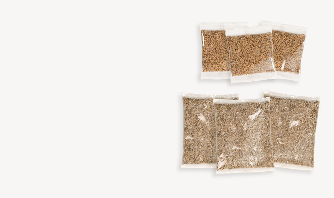 Three small packets of seeds and three larger packets of soil for a cat grass growing kit