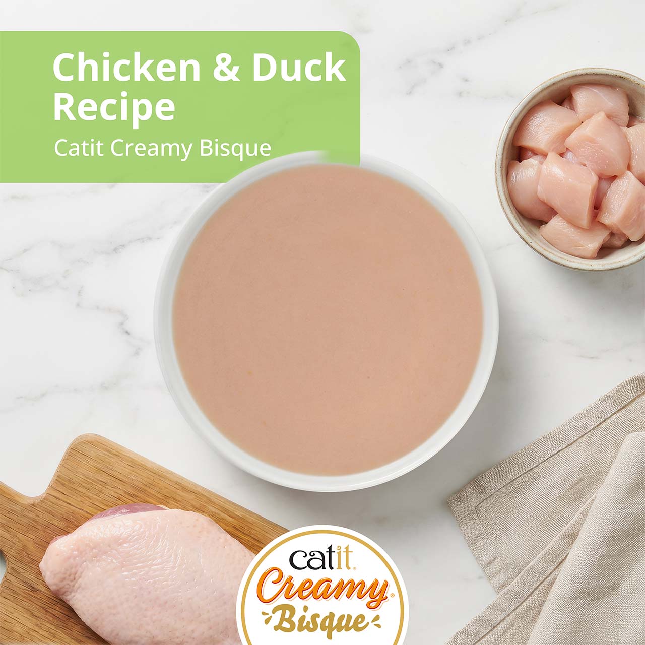 Catit Creamy Bisque cat treat in Chicken with Duck flavor, featuring a bowl of bisque, raw chicken, and duck breast