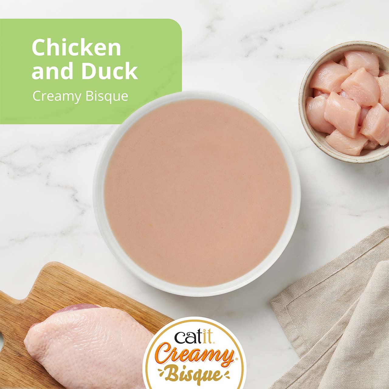 Catit Creamy Bisque cat treat in Chicken with Duck flavor, featuring a bowl of bisque, raw chicken, and duck breast