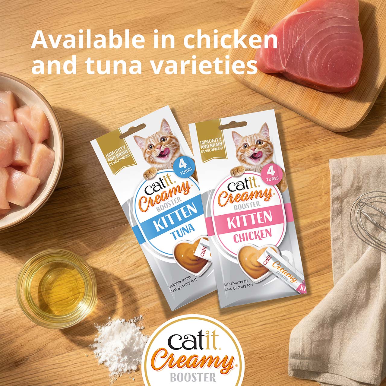 Catit Creamy Booster Kitten packagings laying on wooden countertop with ingredients around, top view