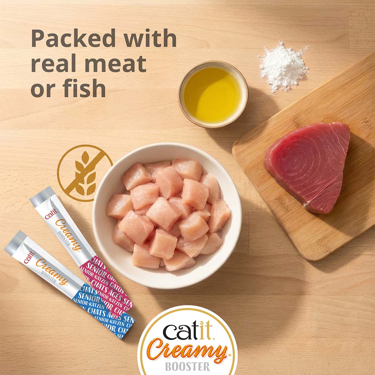 Catit Creamy Booster senior cat treat advertisement highlighting real meat or fish, grain-free ingredients, and added nutrients