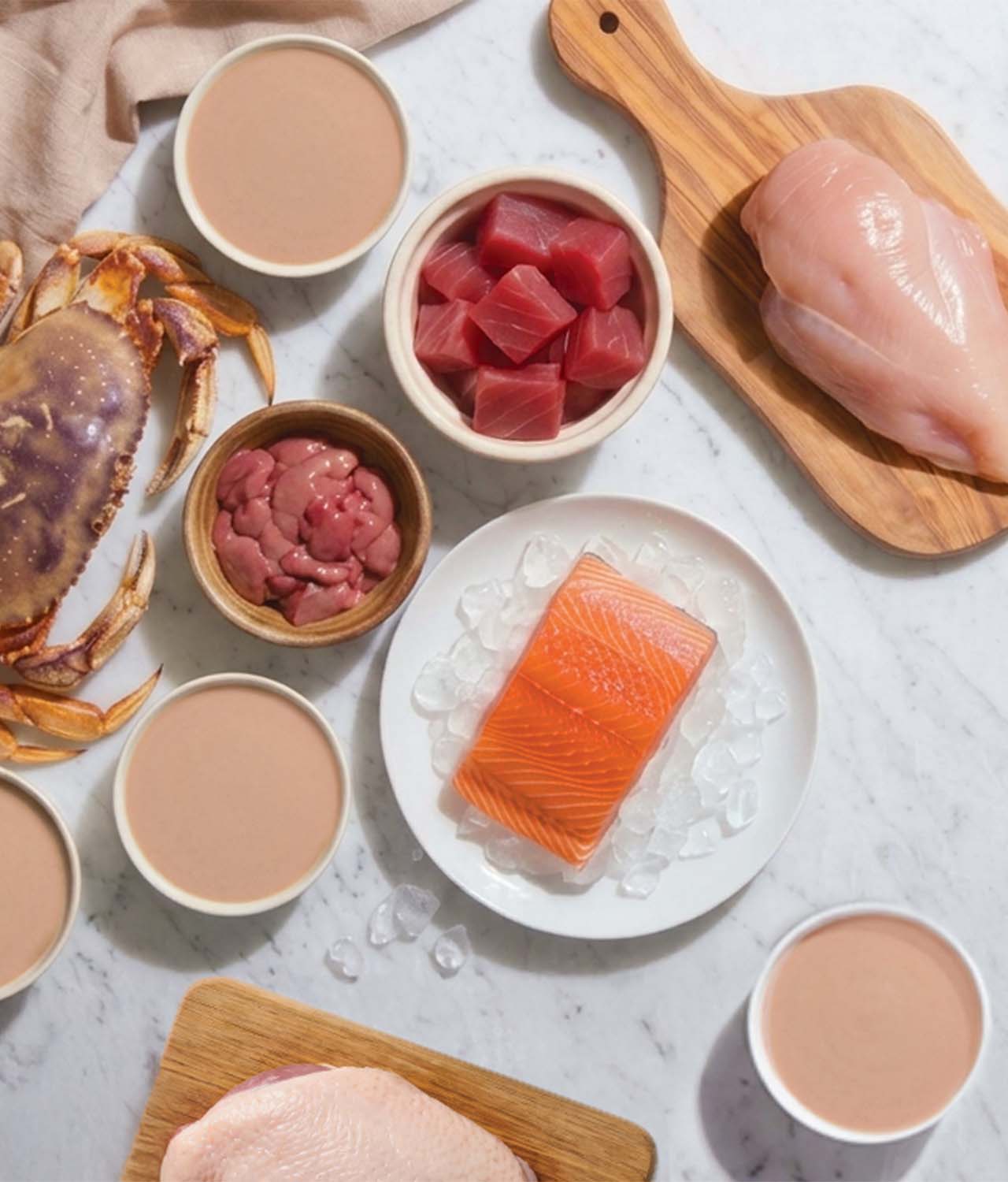 Fresh ingredients on marble counter top with plates of Creamy bisque