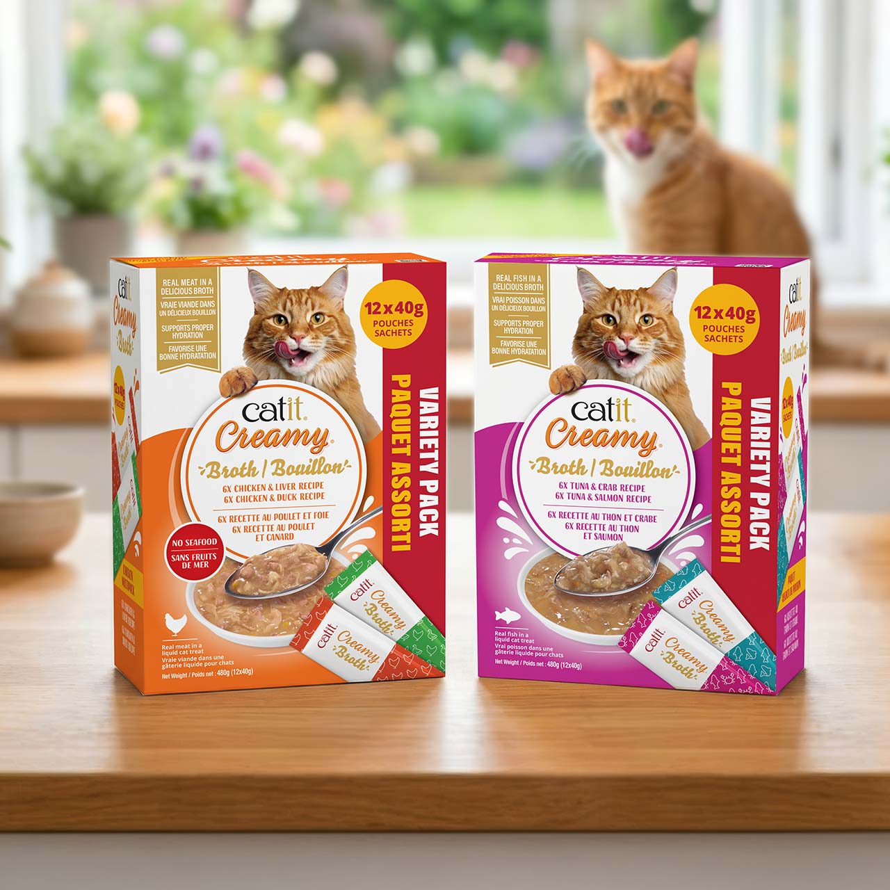 Catit Creamy Broth Multipacks on wooden countertop in kitchen with orange cat in the background looking at the packagings