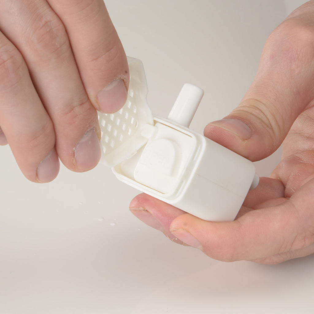 Hand removing the cap of the PIXI Mini Fountain pump